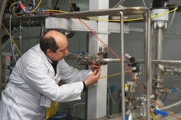 An unidentified International Atomic Energy Agency (IAEA) inspector disconnects the connections between the twin cascades for 20 percent uranium production at nuclear research center of Natanz, on January, 20, 2014. (AFP)