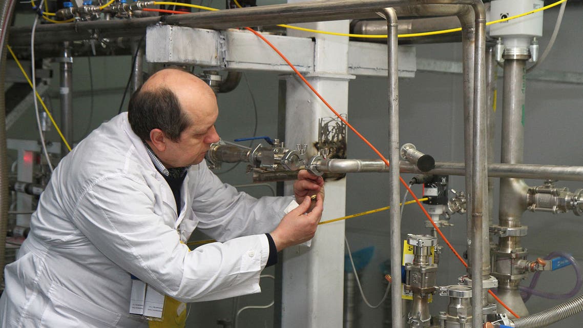 An unidentified International Atomic Energy Agency (IAEA) inspector disconnects the connections between the twin cascades for 20 percent uranium production at nuclear research centre of Natanz, some 300 kilometres south of Tehran on January, 20, 2014 as Iran halted production of 20 percent enriched uranium, marking the coming into force of an interim deal with world powers on its disputed nuclear programme. AFP PHOTO/IRNA/KAZEM GHANE / AFP / IRNA / KAZEM GHANE
