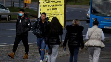 People walk past a sign encouraging the public to get their coronavirus disease (COVID-19) vaccine doses in Manchester, Britain, October 25, 2021. (Reuters)