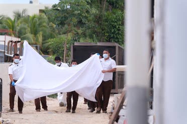 Police hold a bed sheet in an attempt to block onlookers after an armed confrontation close to a hotel near Puerto Morelos, Mexico, Thursday, November 4, 2021. (AP)