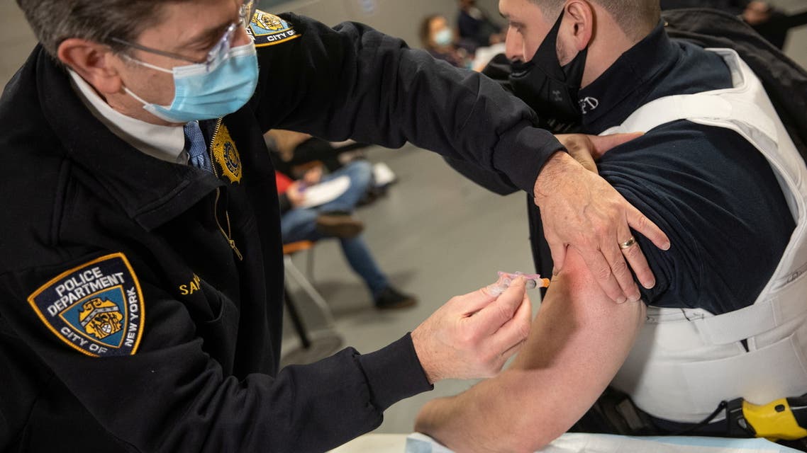 A member of the New York Police Department (NYPD) receives a dose of the Moderna Covid-19 vaccine at Queens Police Academy in the Queens borough of New York, U.S., January 11, 2021. Jeenah Moon/Pool via REUTERS