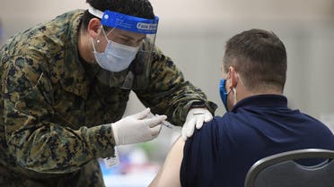PHILADELPHIA, PA - MARCH 02: A member of the U.S. Armed Forces administers a COVID-19 vaccine to a police officer at a FEMA community vaccination center on March 2, 2021 in Philadelphia, Pennsylvania. Located at the Pennsylvania Convention Center, the site is being run as a partnership between the city and the federal government. It is part of a nearly $4 billion plan for FEMA to support more than 400 community vaccination centers across the country. Mark Makela/Getty Images/AFP / Getty Images via AFP / GETTY IMAGES NORTH AMERICA / Mark Makela