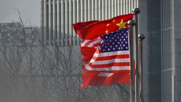 Chinese and US national flags flutter at the entrance of a company office building in Beijing on January 19, 2020. (AFP)