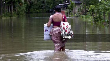 A woman wades through flood waters in the central region of Ratnapura on November 8, 2021. (AFP)