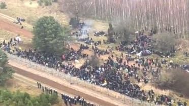 Hundreds of migrants are seen on the Belarus side of the border with Poland, guarded by the Polish soldiers near Kuznica Bialostocka, Poland, in this video-grab released by the Polish Defence Ministry, November 8, 2021. (Handout via Reuters)