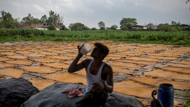 An Indian worker drinks water as processed rawhide are laid to dry at a tannery in Kanpur, an industrial city on the banks of the river Ganges known for its leather tanneries and relentless pollution, in the northern Indian state of Uttar Pradesh, India. (AP)