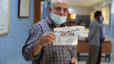 A man shows his voter card inside the polling station in Tripoli, Libya November 8, 2021.  (Reuters)