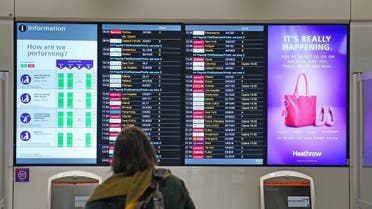 A passenger looks at a departures board at London Heathrow Airport’s T3 as the US reopens its borders to UK visitors in a significant boost to the travel sector, in London, on Nov. 8, 2021. (AP)