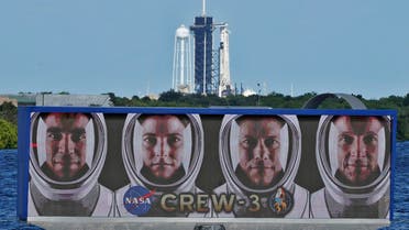 The official portraits of astronauts, from left, Raja Chari, Kayla Barron, Matthias Maurer, of Germany, and Tom Marshburn, are displayed as a SpaceX Falcon 9 rocket with the crew dragon capsule attached sits on Launch Pad 39-A at the Kennedy Space Center in Cape Canaveral, Fla., Friday, Oct. 29, 2021. (File photo: AP)
