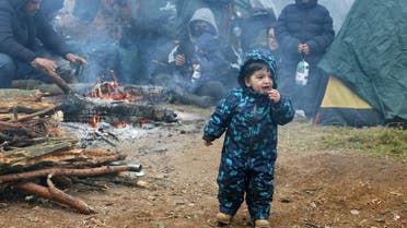 A child reacts as migrants gather in a camp near the Belarusian-Polish border as they attempt to cross it in the Grodno region, Belarus November 10, 2021. Leonid Scheglov/BelTA/Handout via REUTERS ATTENTION EDITORS - THIS IMAGE HAS BEEN SUPPLIED BY A THIRD PARTY. NO RESALES. NO ARCHIVE. MANDATORY CREDIT. TPX IMAGES OF THE DAY