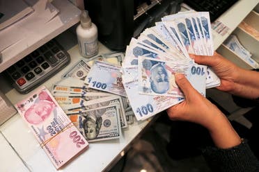 A money changer holds Turkish lira banknotes at a currency exchange office in Ankara, Turkey October 12, 2021. (Reuters)