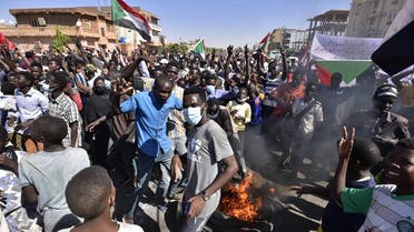 People gather with Sudanese national flags as they protest against the military coup in Sudan, in Street 60 in the east of capital Khartoum on November 13, 2021. (AFP)