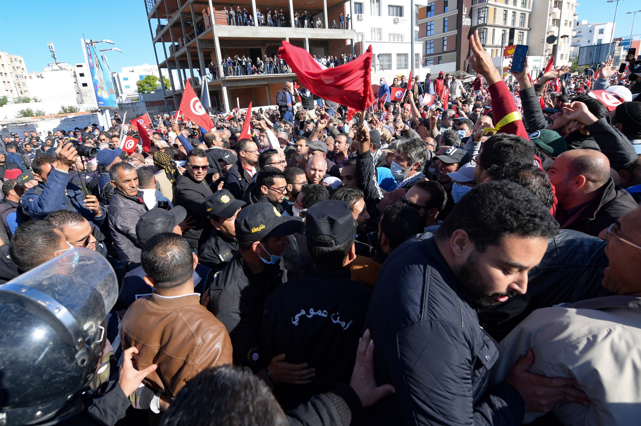Tunisian demonstrators wave national flags as they protest in front of the parliament, against their President Kais Saied's seizure of governing powers, in the capital Tunis, on November 14, 2021. (AFP)