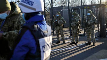 Ukrainian border guards stand guard as OSCE observers cross the checkpoint between the Kiev-controlled territory and occupied areas in the war-torn east, in the town of Schastya in the Lugansk region on November 10, 2020. Ukraine opened on November 10, 2020, two new crossing points in the war-torn east but its attempt to facilitate the movement of civilians was hampered by separatists who denied passage to people. After a separatist uprising broke out in eastern Ukraine in 2014 and pro-Russian separatists carved out the Donetsk People's Republic and Lugansk People's Republic, travelling from and to Kiev-controlled territory has become a complicated affair. / AFP / Evgeniya MAKSYMOVA