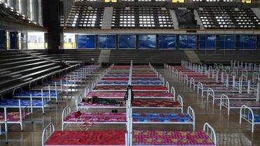 A soldier takes a nap in an empty bed inside the National Olympic Stadium set up as a quarantine center during the latest outbreak of the coronavirus disease (COVID-19) in Phnom Penh, Cambodia, April 26, 2021. (Reuters)