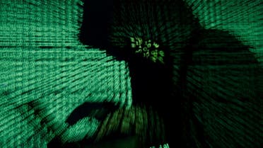 A man holds a laptop computer as cyber code is projected on him in this illustration picture taken on May 13, 2017. (Reuters)