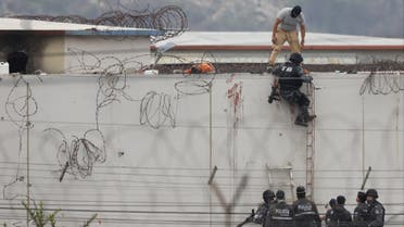  Members of the Ecuadorian police are seen next to the body of an inmate on the roof of a pavilion of the Guayas 1 prison in Guayaquil, Ecuador, on November 13, 2021. (AFP)