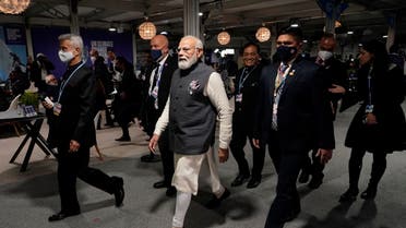 India’s Prime Minister Narendra Modi, center, walks down a corridor inside the venue of the COP26 UN Climate Summit in Glasgow, Scotland, on Nov. 2, 2021. (AP)