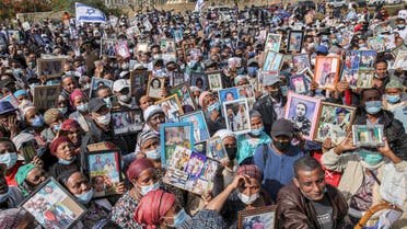 Israelis from the Ethiopian community hold photographs of their relatives during a demonstration demanding the rescue of their relatives left behind amidst the conflict in Ethiopia, outside the Prime Minister's office on Kaplan Street in Jerusalem on November 14, 2021. (AFP)