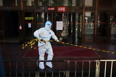 A staff member in a protective suit, following the coronavirus disease (COVID-19) outbreak, removes a cordon outside a quarantine hotel for travellers entering China from abroad, in Dalian, Liaoning province, China September 29, 2021. (Reuters)