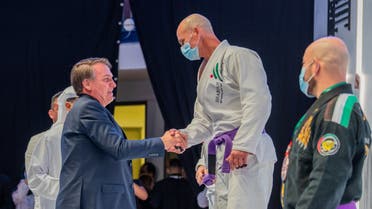 Brazilian President Jair Bolsonaro congratulates a competitor at the ADWJPPC jiu jitsu tournament in Abu Dhabi. (UAE Jiu Jitsu Federation via Twitter)
