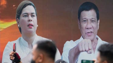A vehicle bearing photos of Philippine President Rodrigo Duterte, right, and his daughter Davao City Mayor Sara Duterte passes by outside the Commission on Elections in Manila, Philippines, Nov. 15, 2021. (AP/Aaron Favila)