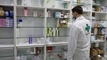 A pharmacy employee holds a box of medication in Beirut, May 28, 2021. (Reuters)