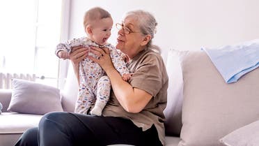 Multi generation family playtime stock photo Grandmother holding little grandson in the room at home. Senior woman hold little baby cute smiling. Happy grandmother with her grandchild in home.