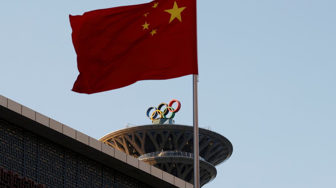 FILE PHOTO: A Chinese flag flutters near the Olympic rings on the Olympic Tower in Beijing, China November 11, 2021. REUTERS/Carlos Garcia Rawlins/File Photo