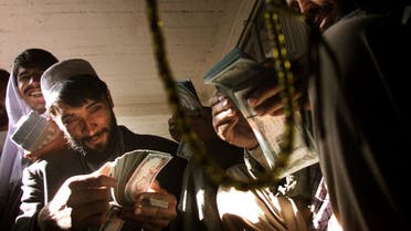 File photo of Afghan traders count money in their market in central Kabul. (Reuters)