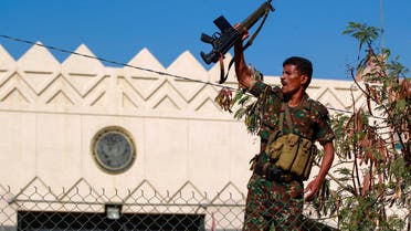 A security member loyal to Yemen's Huthi movement lifts his firearm during a demonstration in front of the closed US Embassy in the capital Sanaa, on January 18, 2021, to reject the outgoing US administration's decision to designate the Huthis a foreign terrorist organisation. Impoverished Yemen is mired in a devastating conflict between Iran-backed Huthi rebels and government forces backed by Saudi Arabia that has left tens of thousands dead and sparked a dire humanitarian crisis. / AFP / Mohammed HUWAIS