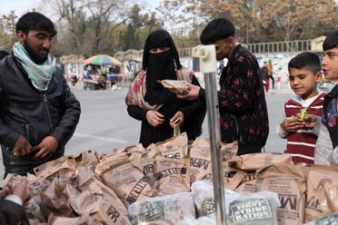 سيدة في كابل تشتري طعاماً تركه الأميركيون بعدما غادروا المدينة