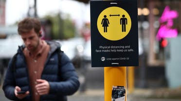 A man walks by a social distancing sign on the first day of New Zealand's new coronavirus disease (COVID-19) safety measure that mandates wearing of a mask on public transport, in Auckland, New Zealand, August 31, 2020. (Reuters)