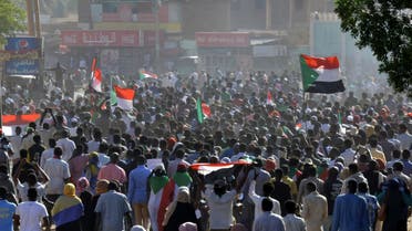 Sudanese protesters lift national flags during a demonstration calling for a return to civilian rule in 40th street in the capital's twin city of Omdurman, on November 21, 2021. (AFP)
