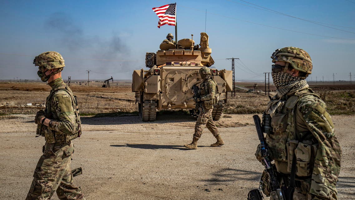 TOPSHOT - US soldiers walk while on patrol by the Suwaydiyah oil fields in Syria's northeastern Hasakah province on February 13, 2021. / AFP / Delil SOULEIMAN