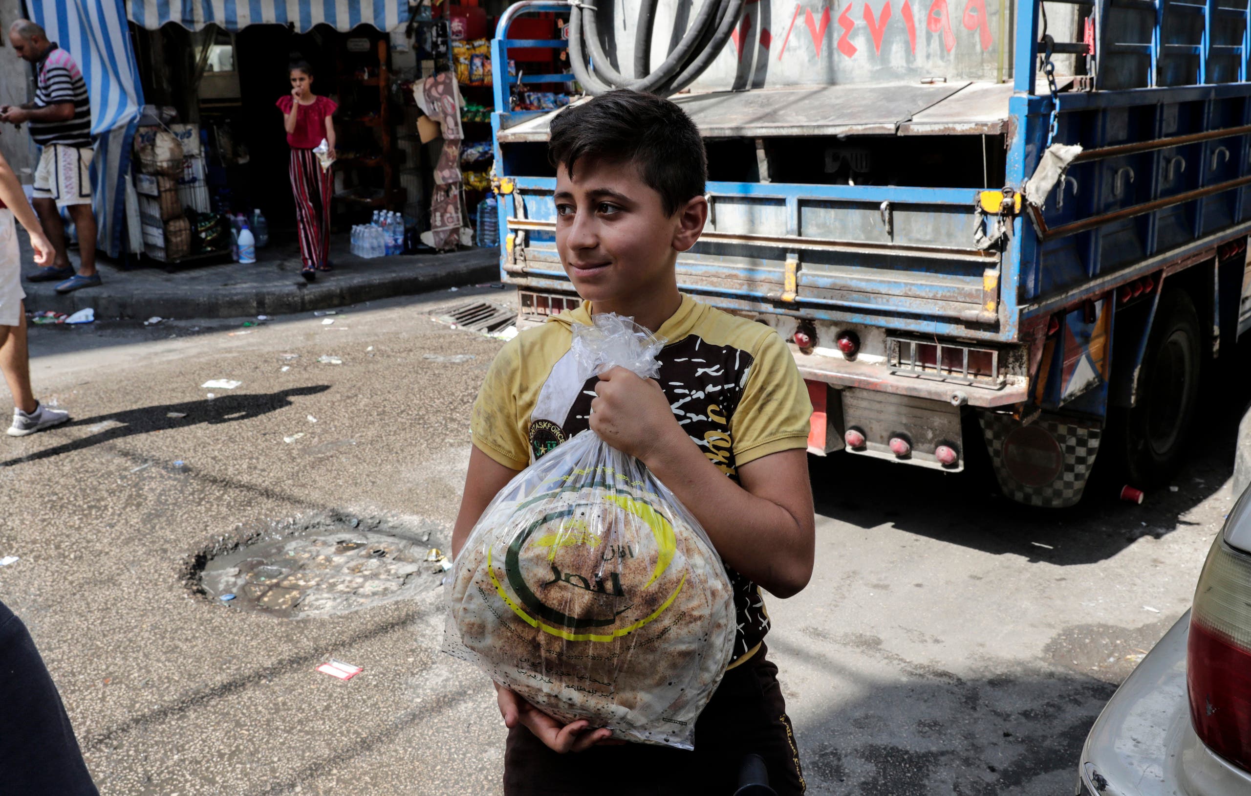 طفل يشتري الخبز في حي النبعة الفقير في بيروت