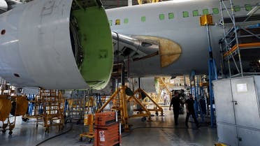 Laborers work inside and around a passenger plane as they convert it into a cargo plane at Israel Aerospace Industries’ site in Ben Gurion International Airport, Lod, Israel, December 10, 2020. (Reuters/Ronen Zvulun)