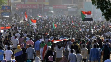 Sudanese protesters lift national flags during a demonstration calling for a return to civilian rule in 40th street in the capital's twin city of Omdurman, on November 21, 2021. (AFP)