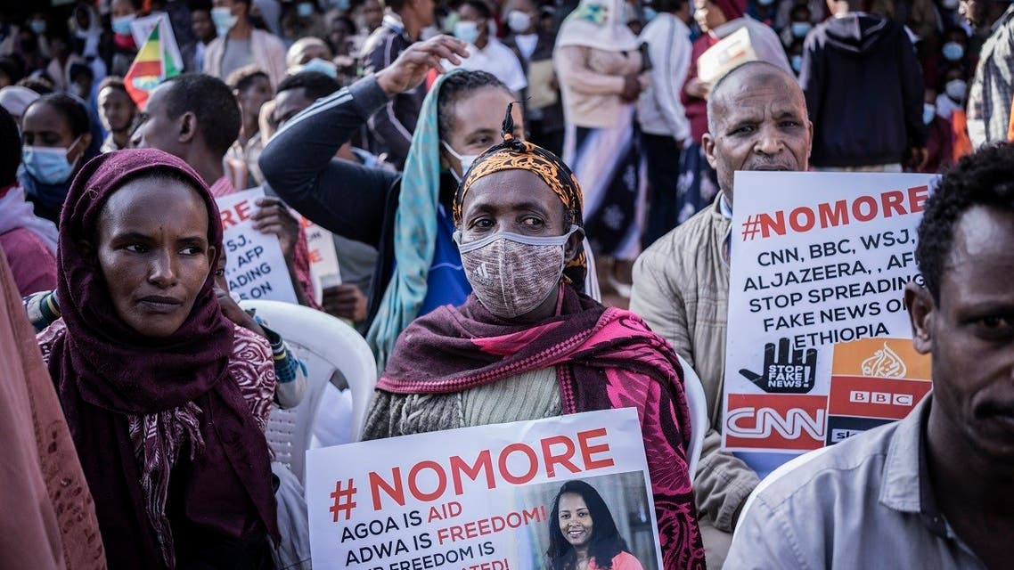 People hold papers showing messages of “NO More” as they protest against purported fake news during the send-off ceremony for New military recruits who are joining the Ethiopian National Defense Force in Addis Ababa, Ethiopia, on November 24, 2021. (Amanuel Sileshi/AFP)