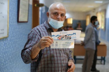 مواطن ليبي يحمل بطاقته الانتخابية (أرشيفية من رويترز)