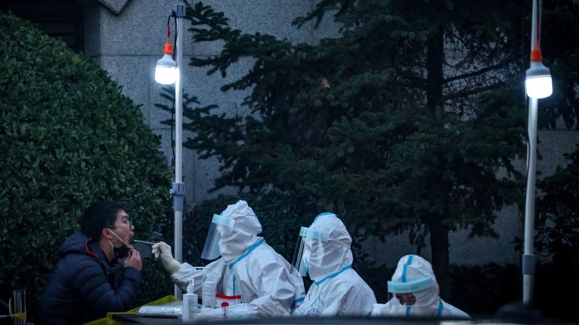 Medical personnel test a man at a makeshift testing site near a residential compound that was locked down after a local outbreak of the coronavirus disease (COVID-19) in Beijing, China, November 11, 2021. REUTERS/Thomas Peter