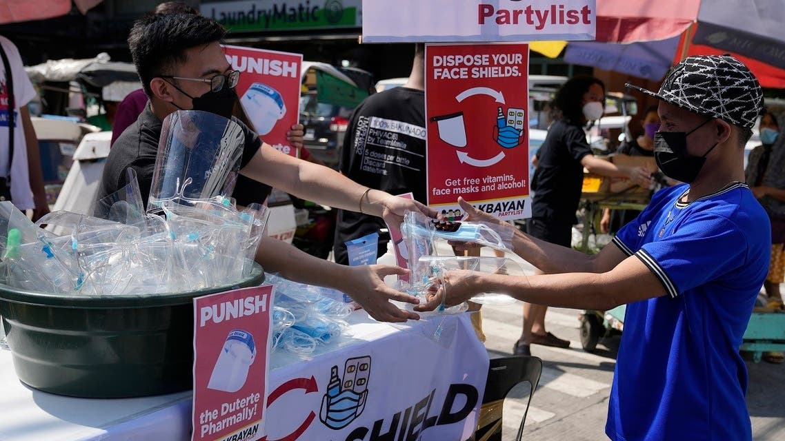 A man brings his used face shield in exchange for free face masks and vitamins at a makeshift station in Quezon City, Philippines on Monday, Nov. 22, 2021 as the group encourages residents to dispose of their face shields properly due to environmental concerns. (AP)