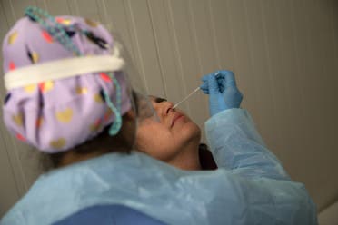 A health worker wearing protective gear collects a nasal swab for a (AFP) Covid-19 PCR test ahead of a music concert in Santiago, on August 26, 2021. (AFP)