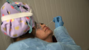 A health worker wearing protective gear collects a nasal swab for a (AFP) Covid-19 PCR test ahead of a music concert in Santiago, on August 26, 2021. (AFP)