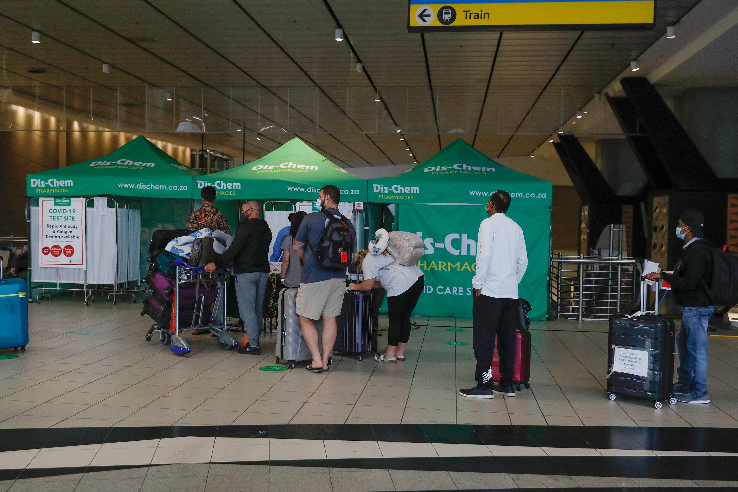 مسافرون ينتظرون للخضوع لفحص كورونا في مطار جوهانسبورغ في جنوب افريقيا حيث تم رصد أوميكرون أولاً