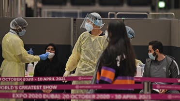 Health workers check passengers who arrived in an Emirates Airlines flight from London at Dubai International Airport on May 8, 2020 amid the coronavirus Covid-19 pandemic. (AFP)