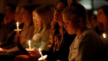 People hold candles during a vigil after a shooting at Oxford High School at Lake Pointe Community Church in Lake Orion, Michigan on November 30, 2021. (AFP)