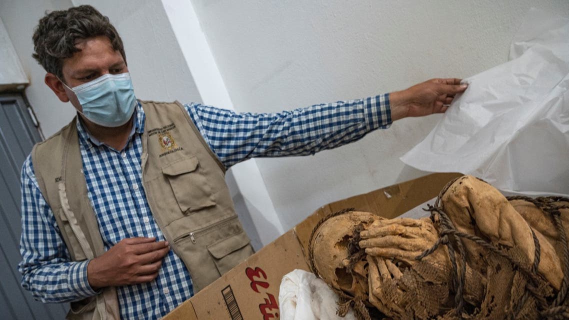 Archaeologist Pieter Van Dalen Luna (L), head responsible for the Cajamarquilla Archeological project shows a mummy estimated to be between 800 and 1,200 years old, unearthed earlier this month at the pre-Inca Cajamarquilla archaeological site, 25 kilometers inland from Lima, on November 30, 2021. (AFP)