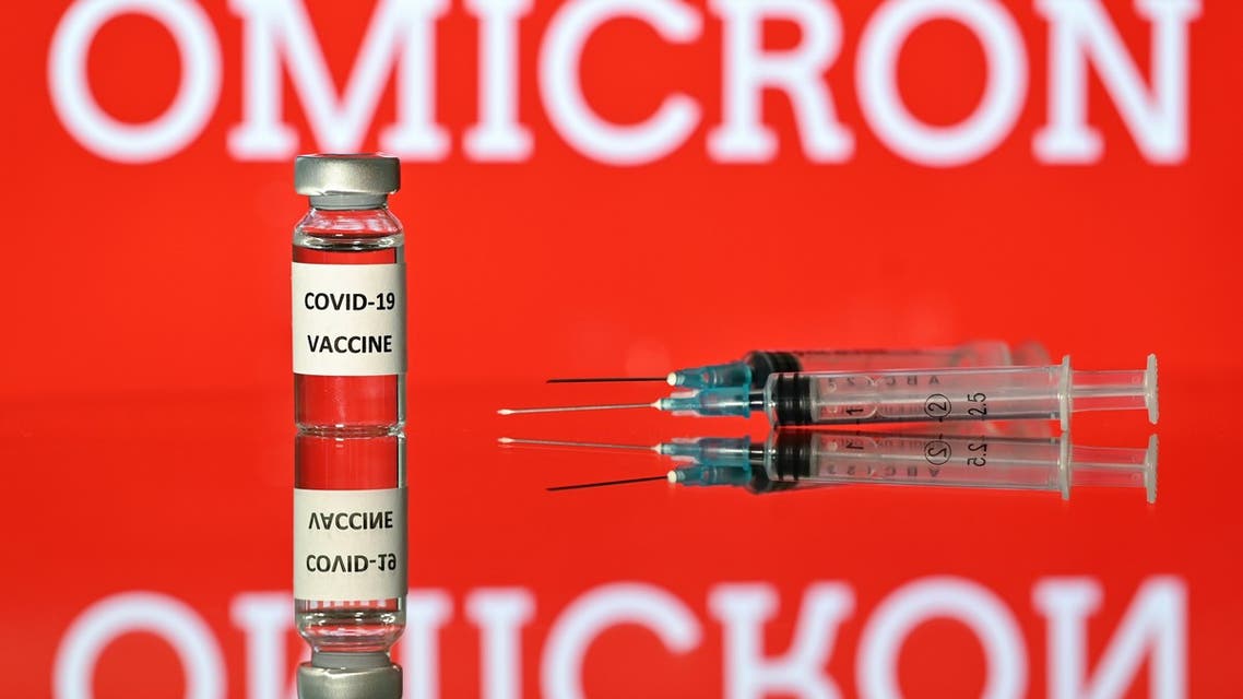 An illustration picture taken in London on December 2, 2021 shows a vial with Covid-19 vaccine sticker attached, beside syringes and a screen displaying the word 'Omicron', the name of the new covid 19 variant. (Photo by Justin TALLIS / AFP)