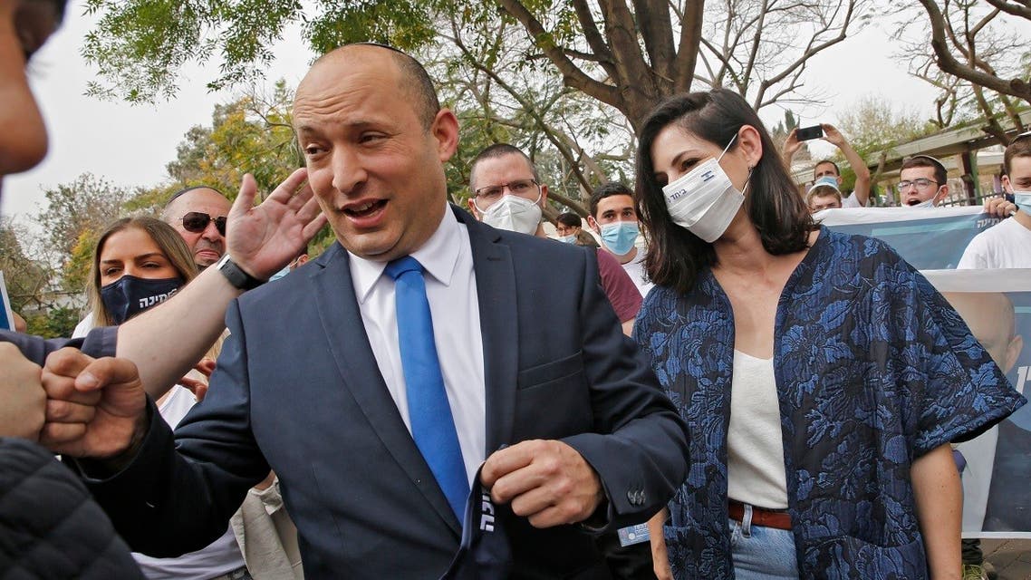 Israel’s Naftali Bennett, leader of the right wing ‘New Right’ party, and his wife Gilat are pictured outside a polling station on March 23, 2021 in the city of Raanana as Israelis voted in their fourth national election in two years. (AFP)